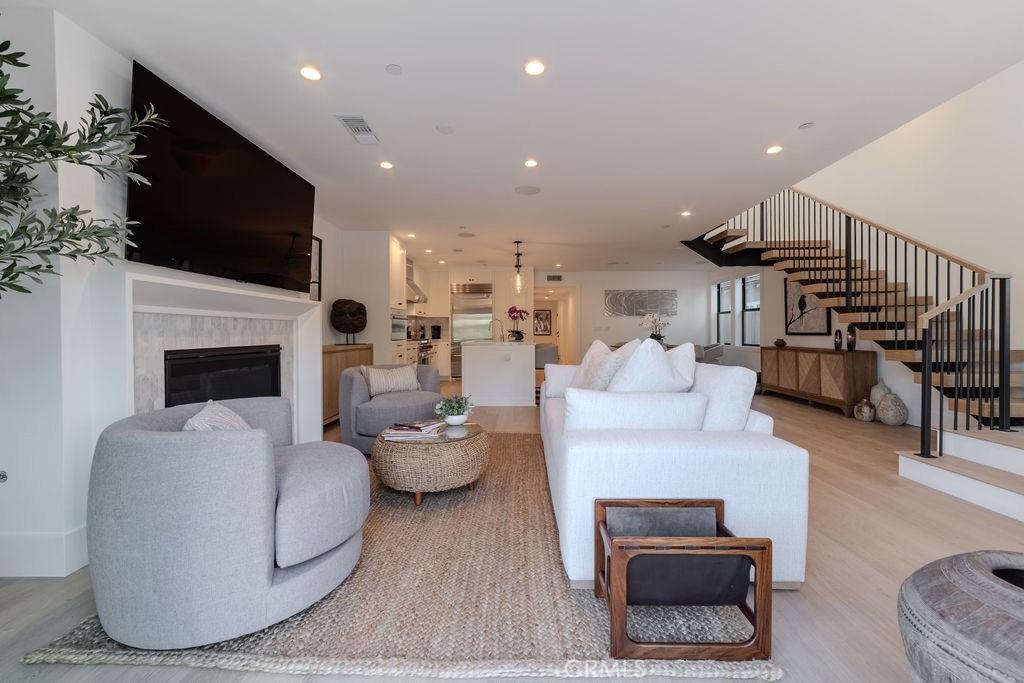 603 Acacia Avenue, Unit A Corona del Mar, CA 92625 - Photo 7 of 53 a living room with furniture a flat screen tv and a fireplace