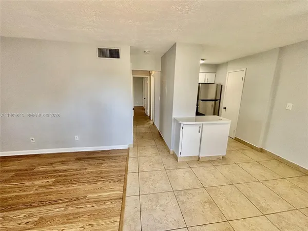 a view of a kitchen with wooden floor and white appliances