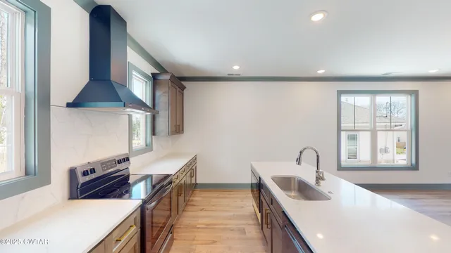 a kitchen with stainless steel appliances a sink a stove and a refrigerator