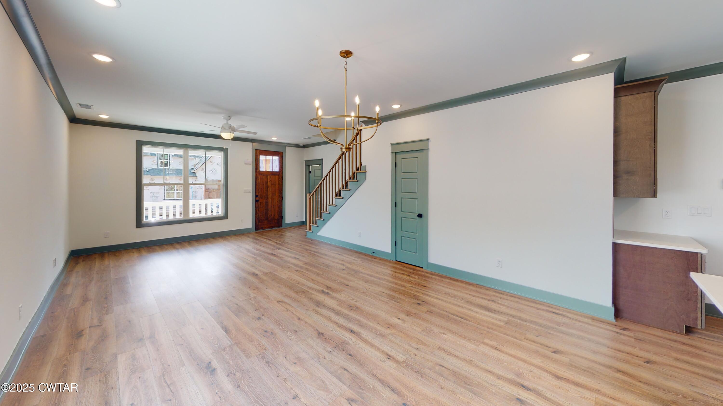 205 McCowat Street Jackson, TN 38301 - Photo 6 of 23 a view of a livingroom with wooden floor and a ceiling fan