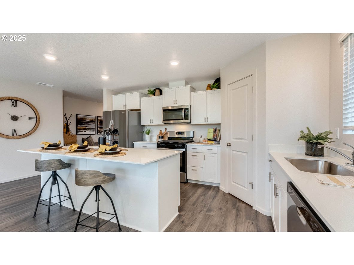 238 Greencrest Street Northeast Salem, OR 97301 - Photo 11 of 26 a living room with stainless steel appliances kitchen island granite countertop a sink a counter top space and cabinets