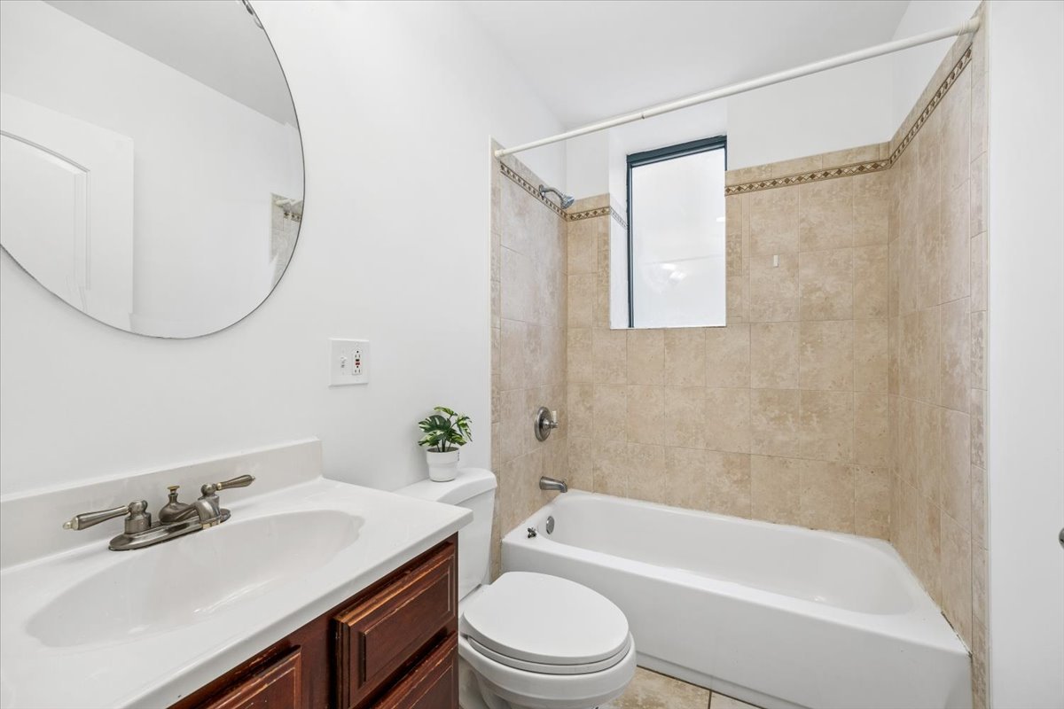 2363 East 70th Street, Unit 1 Chicago, IL 60649 - Photo 9 of 26 a bathroom with a sink a toilet and a mirror