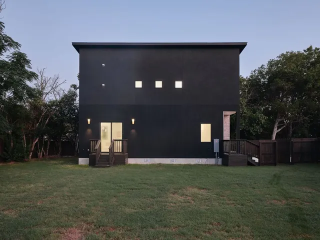 a front view of a house with a yard and trees