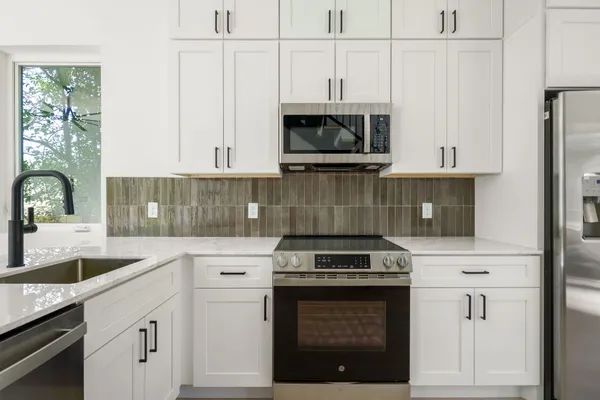 a kitchen with stainless steel appliances a stove sink and cabinets