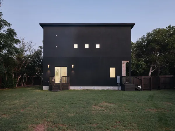 a front view of a house with a yard and trees
