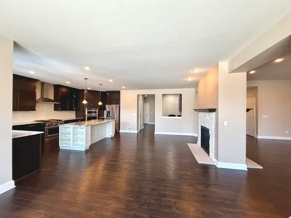 a view of kitchen with stove refrigerator and cabinets