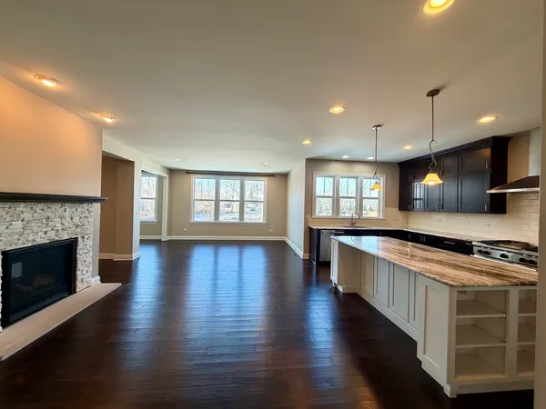 a large kitchen with stainless steel appliances granite countertop a stove and a wooden floors