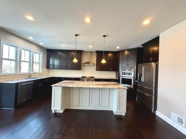 a kitchen with stainless steel appliances a stove a refrigerator a sink and a oven