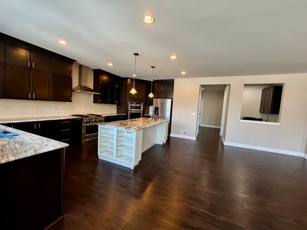 a large kitchen with stainless steel appliances kitchen island a large counter top and a stove top oven