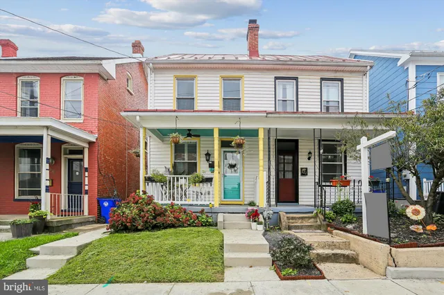 front view of a brick house with a yard