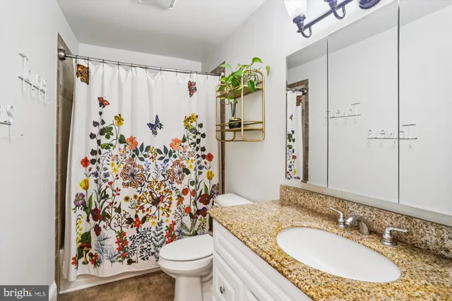 a front view of a building with lot of cars and trees