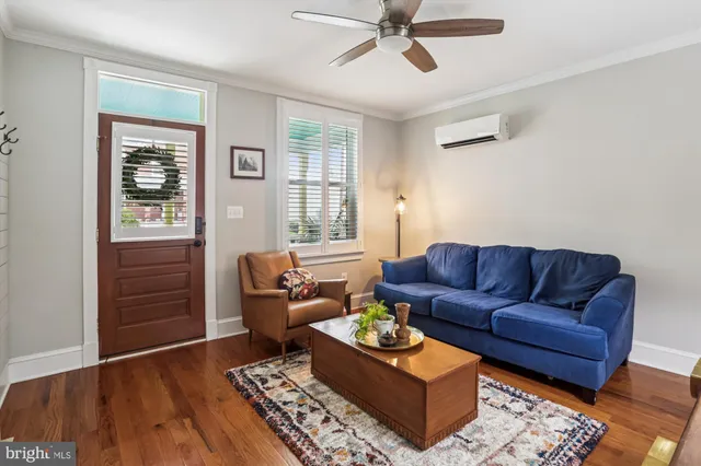 a living room with furniture and a wooden floor