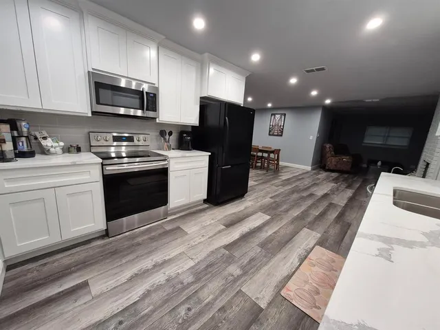 a kitchen with stainless steel appliances granite countertop a refrigerator stove microwave and sink