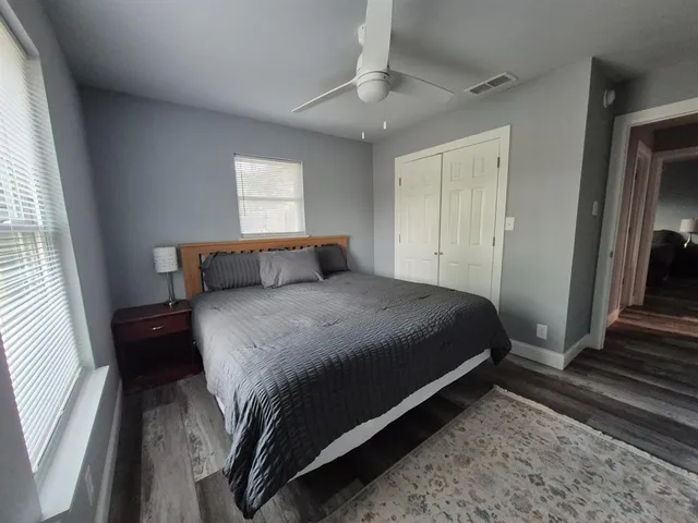 a bedroom with a bed and wooden floor