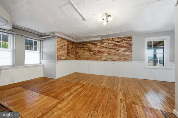 a view of a room with wooden floor windows and a bathroom