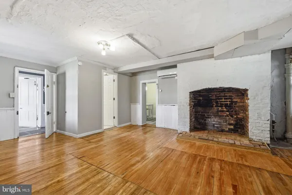 a view of empty room with wooden floor and fireplace