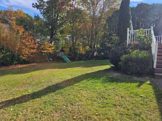 a view of yard with swimming pool and green space