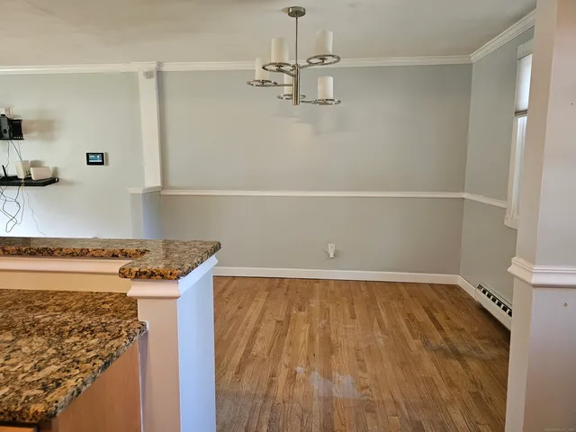 a view of a storage and utility room with wooden floor