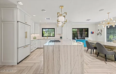 a living room with furniture a chandelier and a dining table