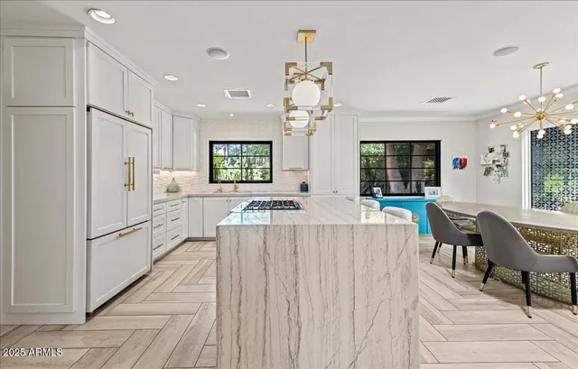 a living room with furniture a chandelier and a dining table