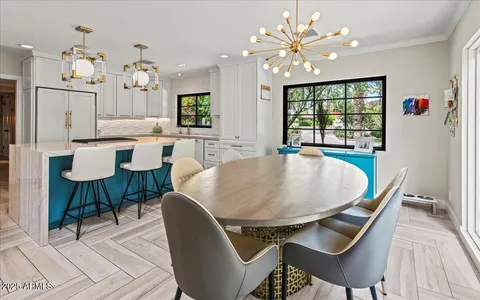 a dining room with furniture a chandelier and wooden floor