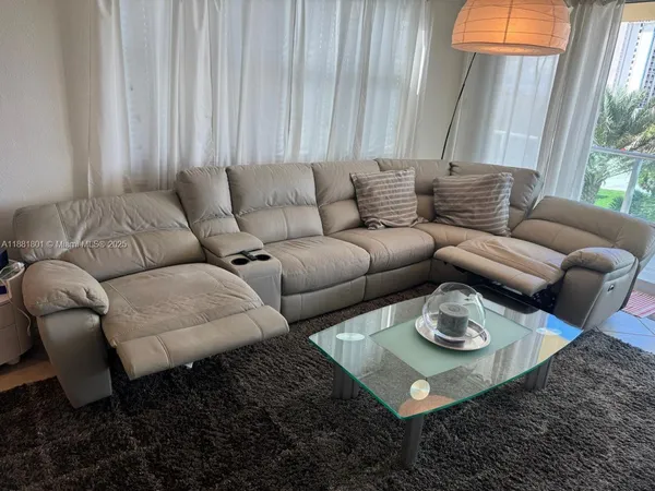 a living room with furniture a rug and a window