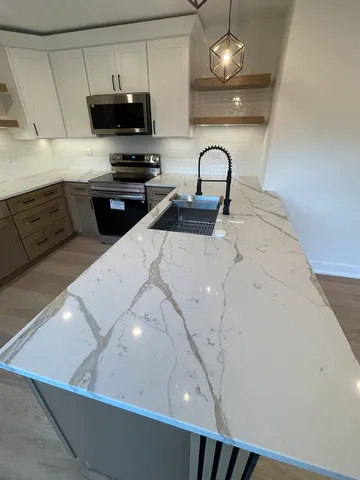 a kitchen with stainless steel appliances a microwave a sink and cabinets