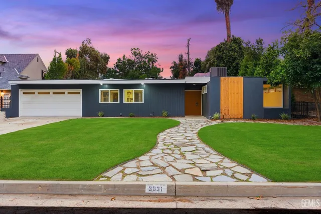 a front view of a house with a yard and trees