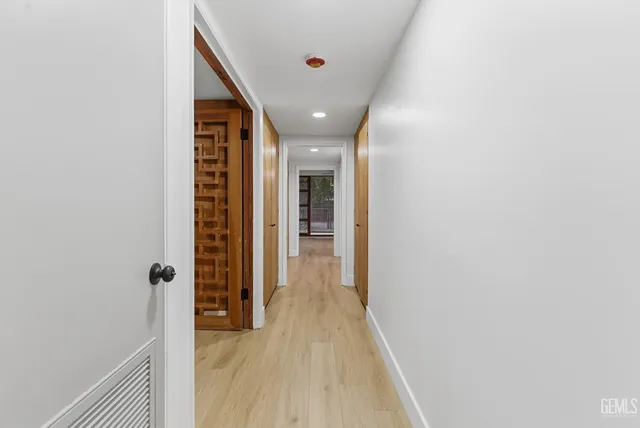 a view of a hallway with wooden floor and staircase