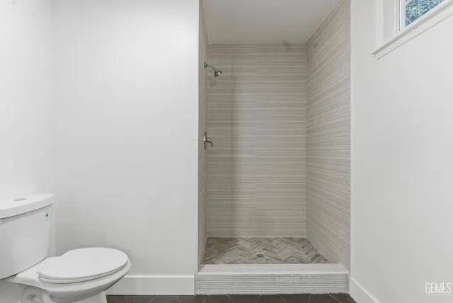 a bathroom with a toilet and a shower