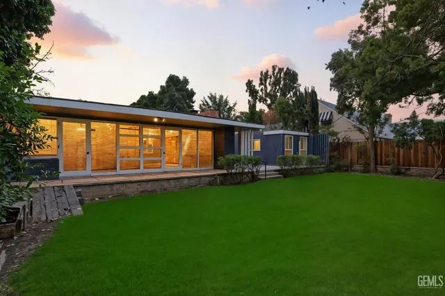 a view of a house with backyard and sitting area