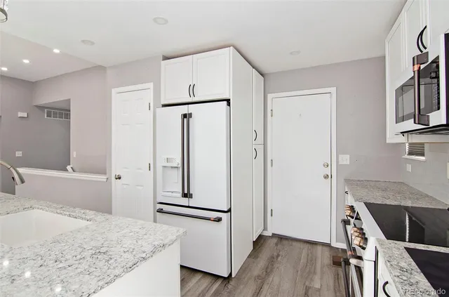 a kitchen with stainless steel appliances a refrigerator and a stove top oven