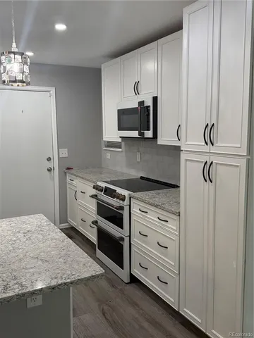 a kitchen with stainless steel appliances granite countertop a stove and a refrigerator