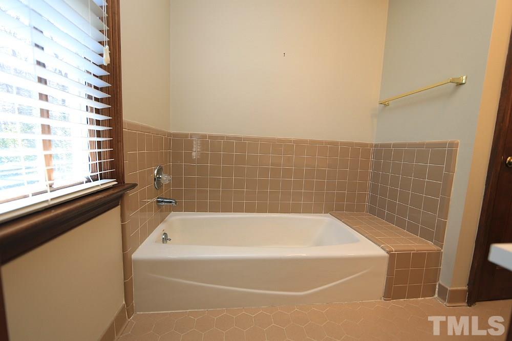 122 Skylark Way Raleigh, NC 27615 - Photo 21 of 30 a white bath tub sitting next to a window
