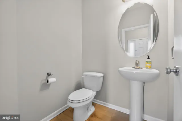 a bathroom with a toilet a sink and mirror