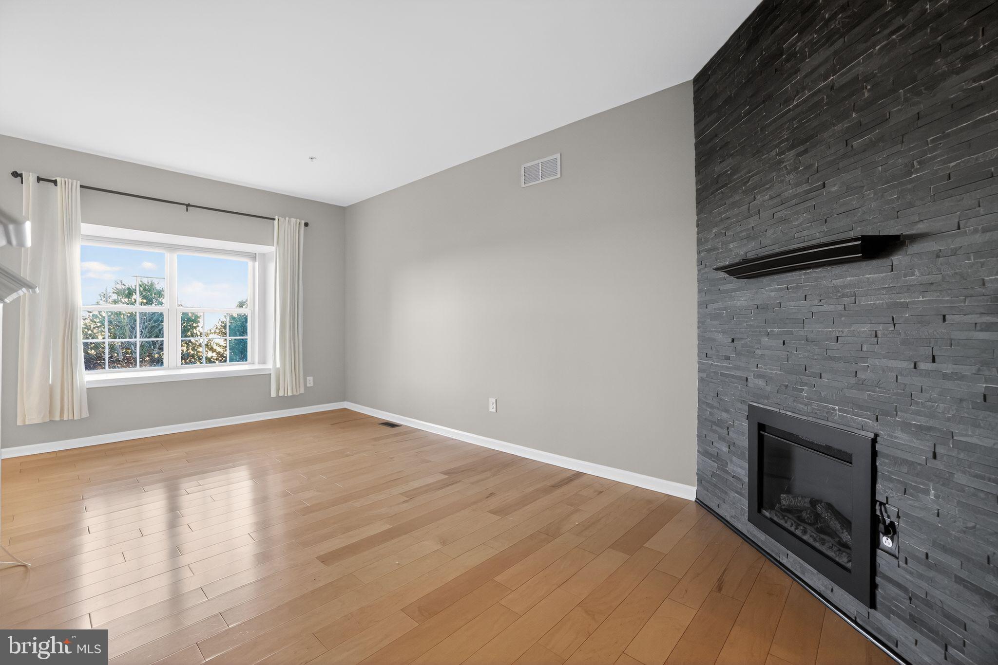 3669 Jacob Stout Road, Unit 8 Doylestown, PA 18902 - Photo 4 of 34 a view of empty room with wooden floor and fireplace