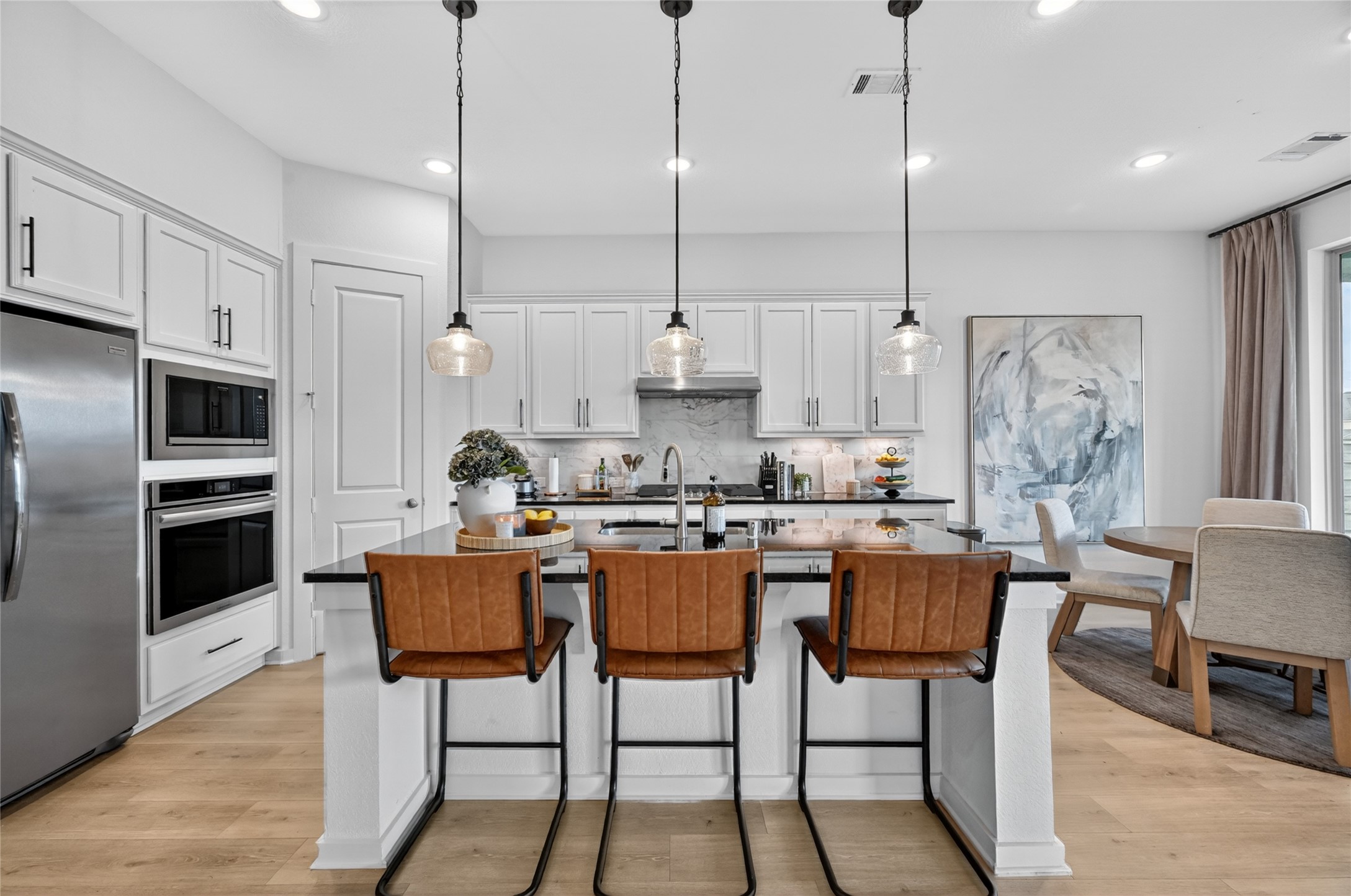 4439 Stone Ridge Lane Manvel, TX 77578 - Photo 12 of 48 a kitchen with stainless steel appliances granite countertop a kitchen island a table and chairs