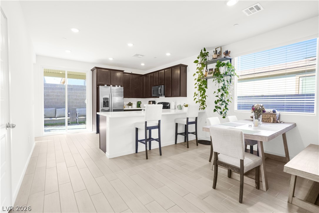 9398 Noble Fir Rdg Court Las Vegas, NV 89143 - Photo 2 of 36 The seamless flow between the dining area and kitchen creates an inviting space for gatherings.