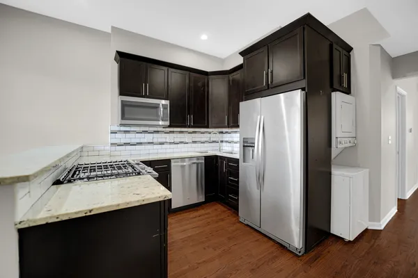 a kitchen with a refrigerator sink and cabinets