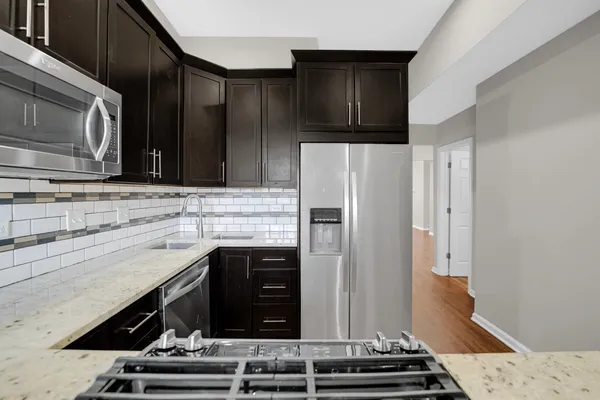 a kitchen with stainless steel appliances granite countertop a refrigerator and a stove
