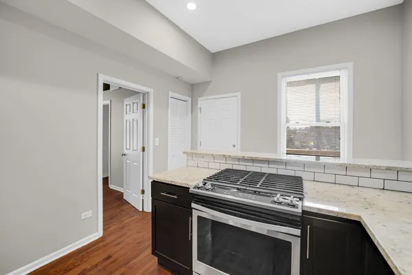 a kitchen with granite countertop a stove and a sink