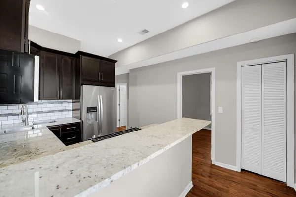a kitchen with stainless steel appliances kitchen island sink refrigerator and cabinets