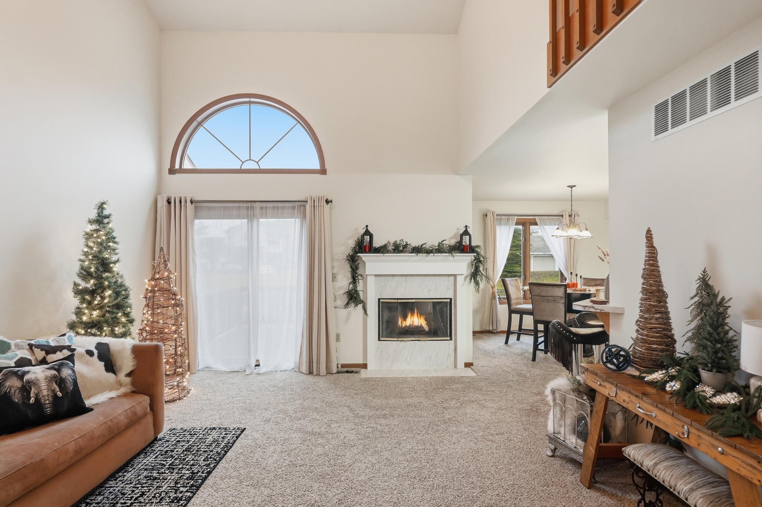 9465 Van Buren Court Crown Point, IN 46307 - Photo 3 of 16 a living room with furniture a fireplace and a potted plant