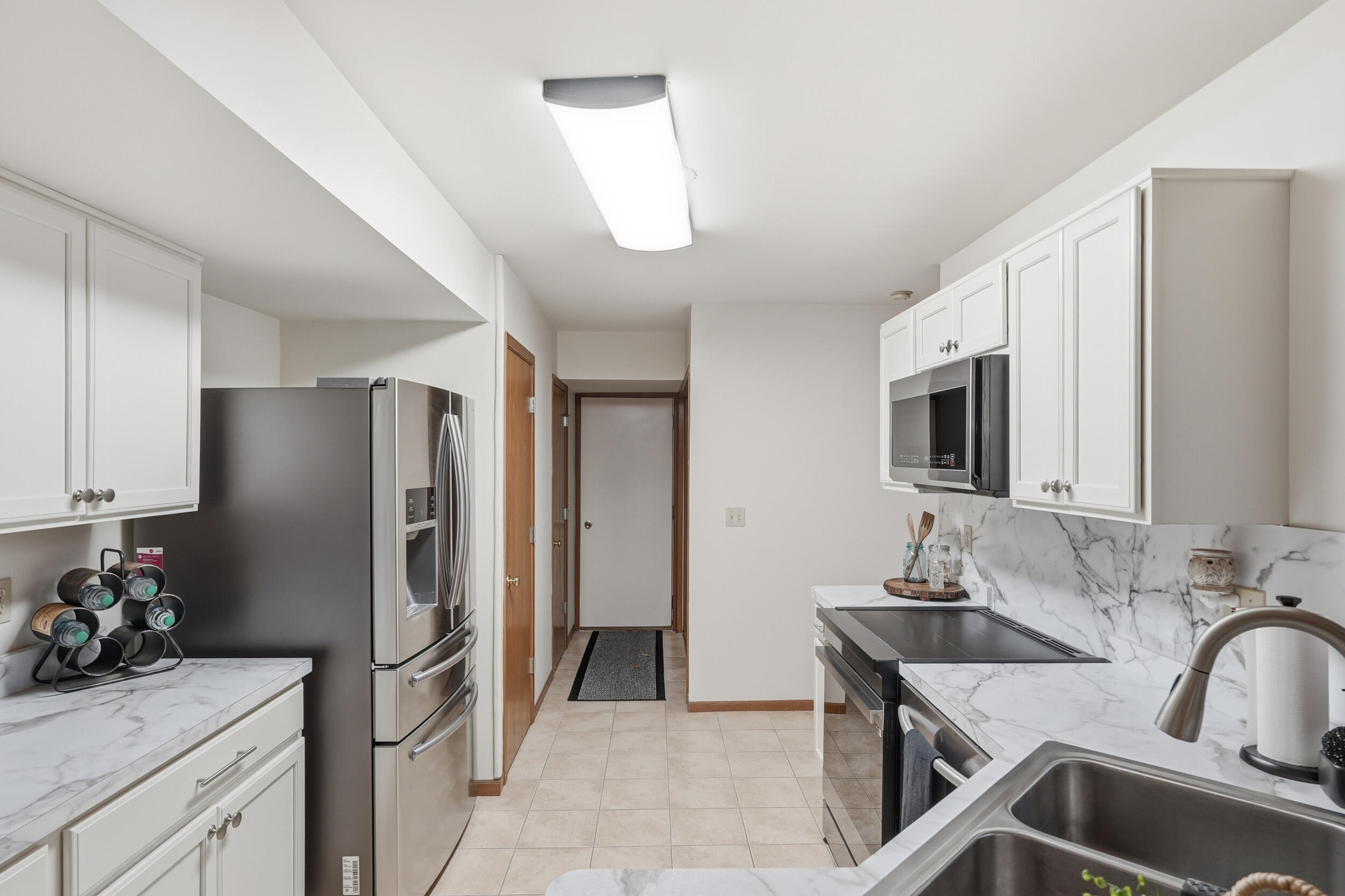 9465 Van Buren Court Crown Point, IN 46307 - Photo 6 of 16 a kitchen with stainless steel appliances a sink stove and refrigerator