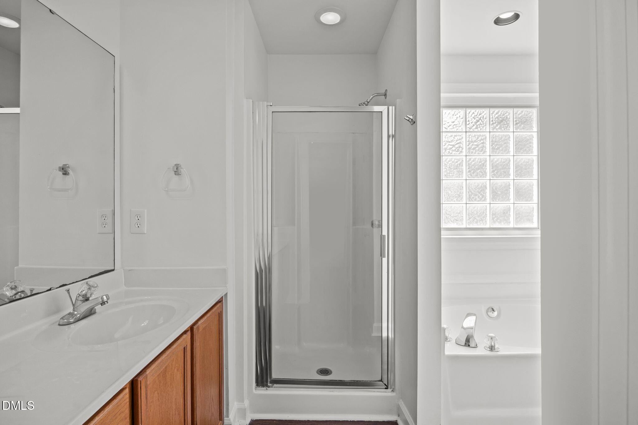9220 Pennythorne Court Raleigh, NC 27615 - Photo 32 of 49 a bathroom with a granite countertop sink a mirror and a shower