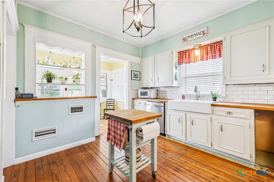1004 Mitchell Street Gonzales, TX 78629 - Photo 17 of 46 a kitchen with stainless steel appliances granite countertop a stove a sink and white cabinets with wooden floor
