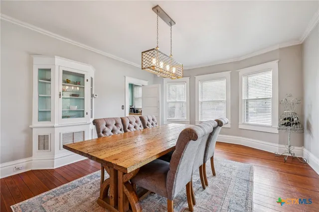 a kitchen with stainless steel appliances granite countertop a stove refrigerator and a dining table with wooden floor