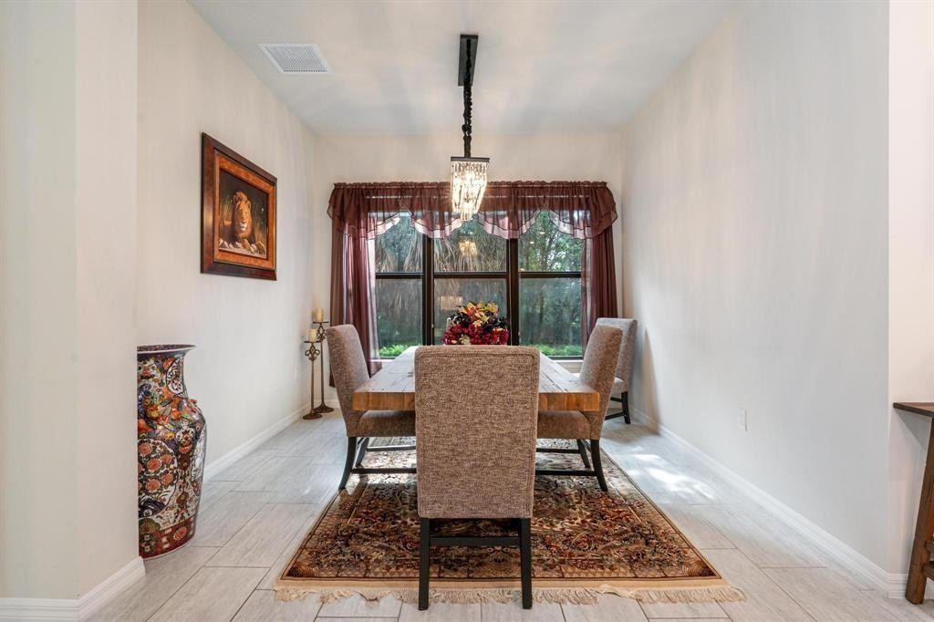9208 Passiflora Way, Unit 102 Boca Raton, FL 33428 - Photo 18 of 30 a dining room with furniture a rug and wooden floor