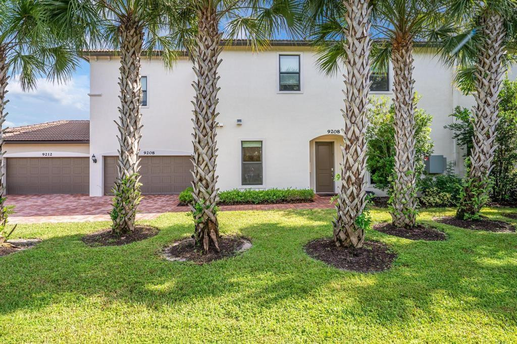 9208 Passiflora Way, Unit 102 Boca Raton, FL 33428 - Photo 4 of 30 a view of a house with a yard and palm trees