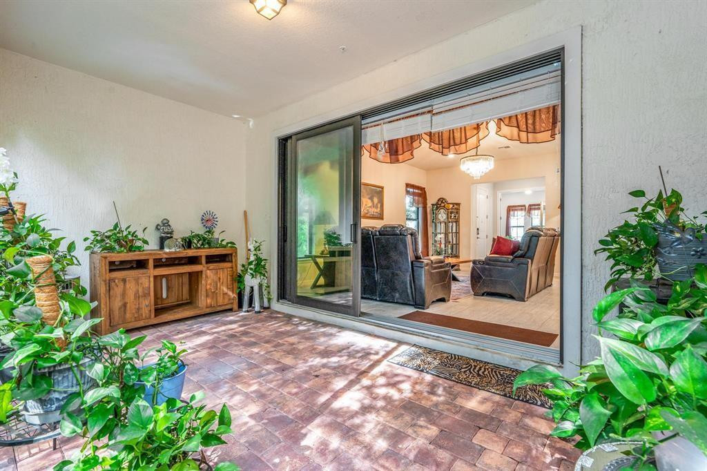 9208 Passiflora Way, Unit 102 Boca Raton, FL 33428 - Photo 6 of 30 a view of a porch with chairs and potted plants